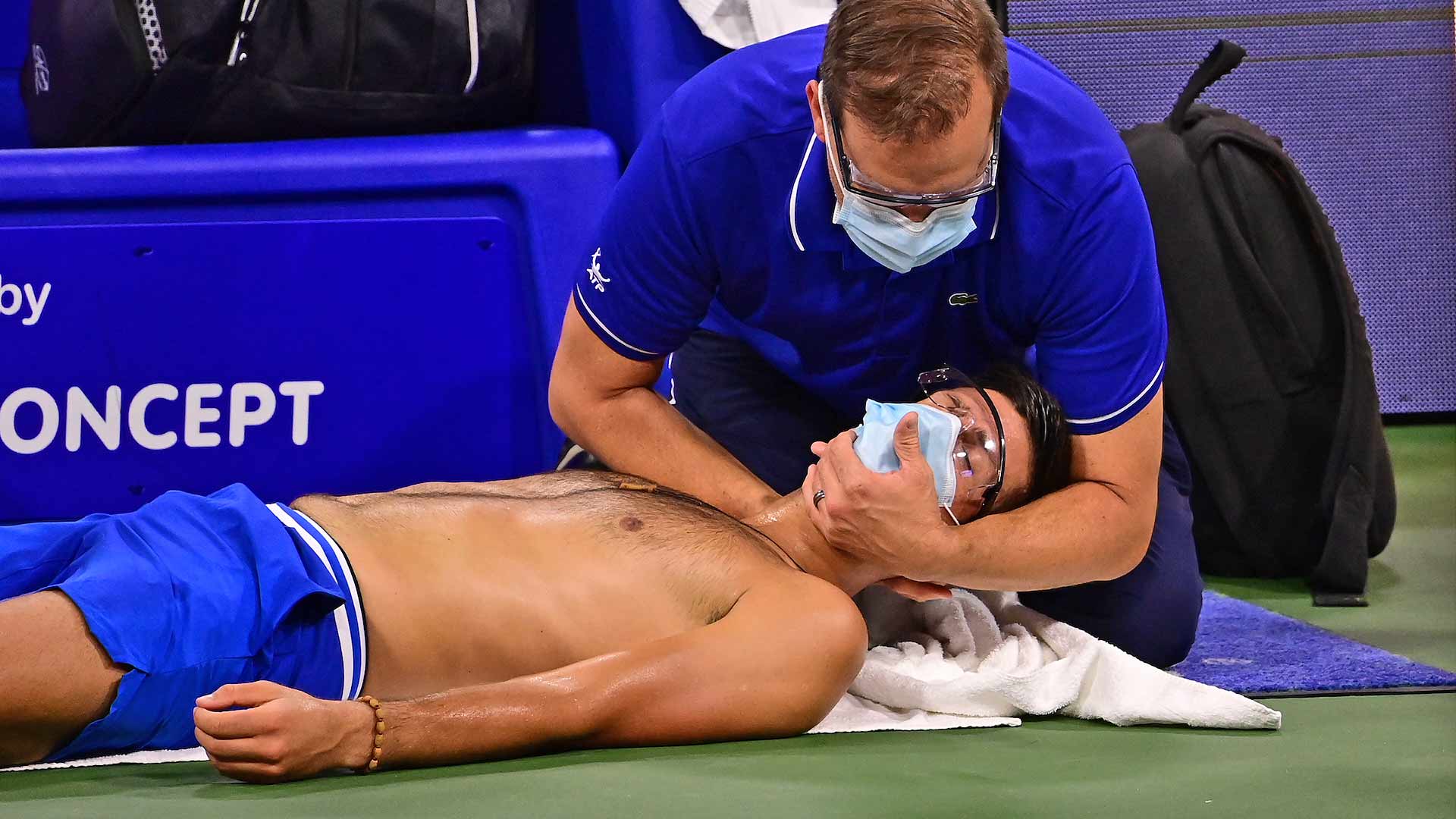 <a href='/en/players/novak-djokovic/d643/overview'>Novak Djokovic</a> receives a neck adjustment after the first set.