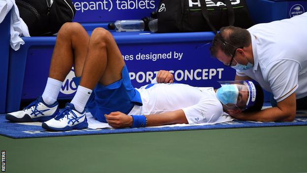 Novak Djokovic receives treatment on a neck injury