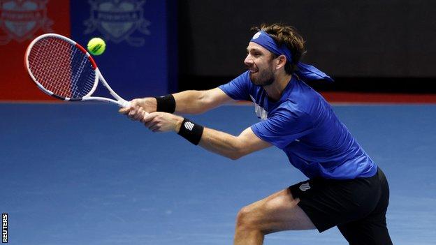 Cameron Norrie returns a ball against Andrey Rublev