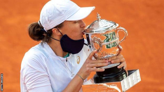 Iga Swiatek kisses the French Open trophy